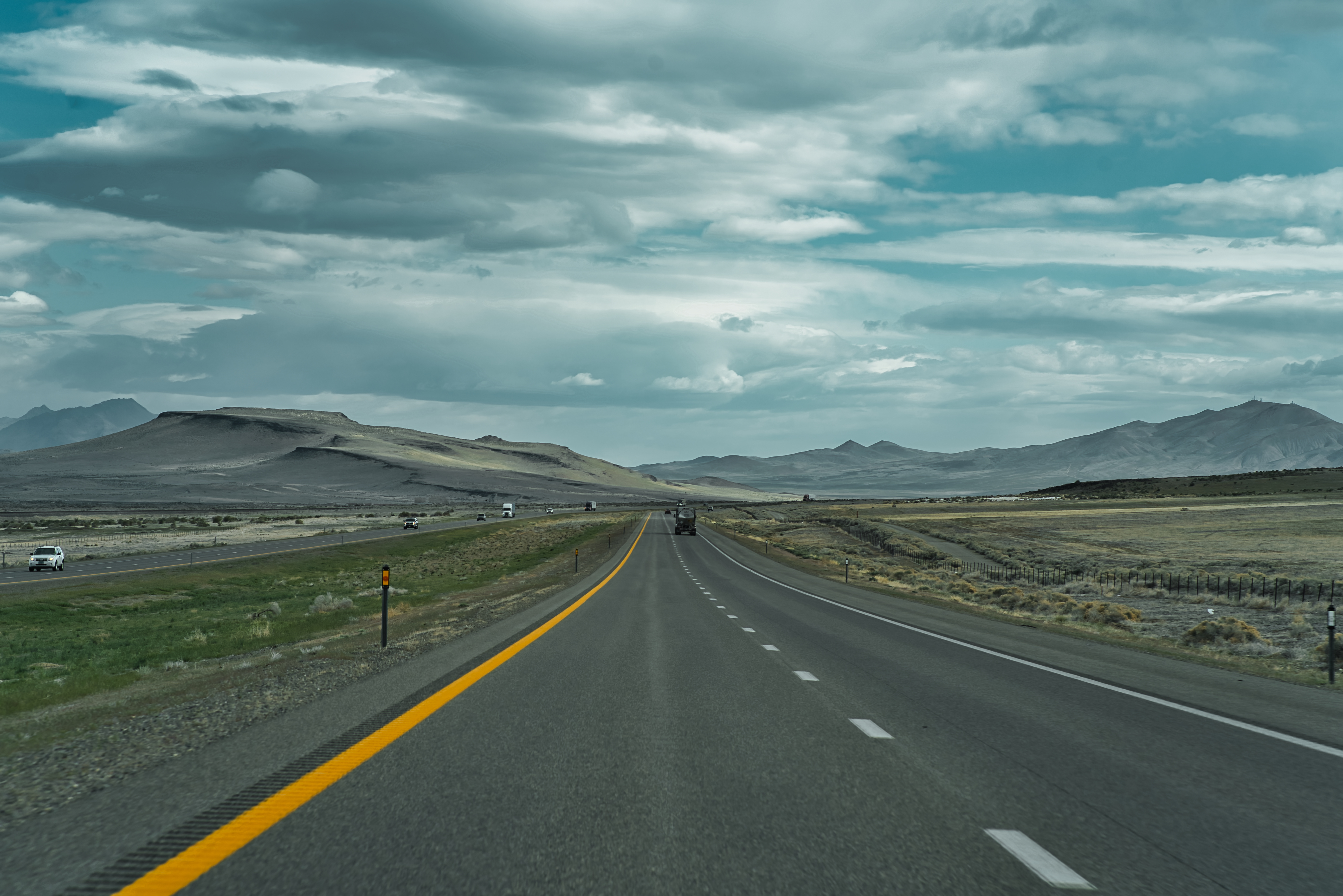 highway toward scenic mountainscape with sparse traffic. Image Credit: AdobeStock_502427825